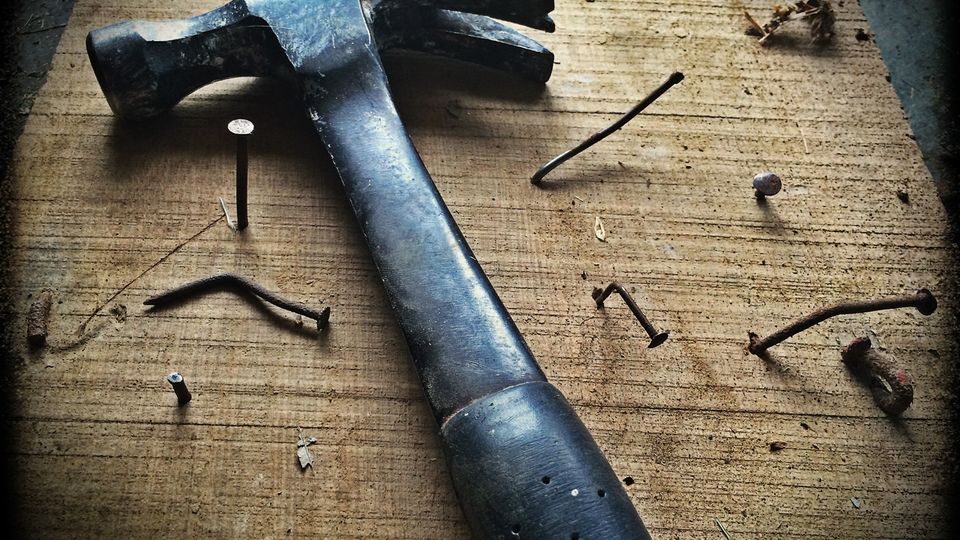 Hands tightening a pipe fitting with an adjustable wrench
