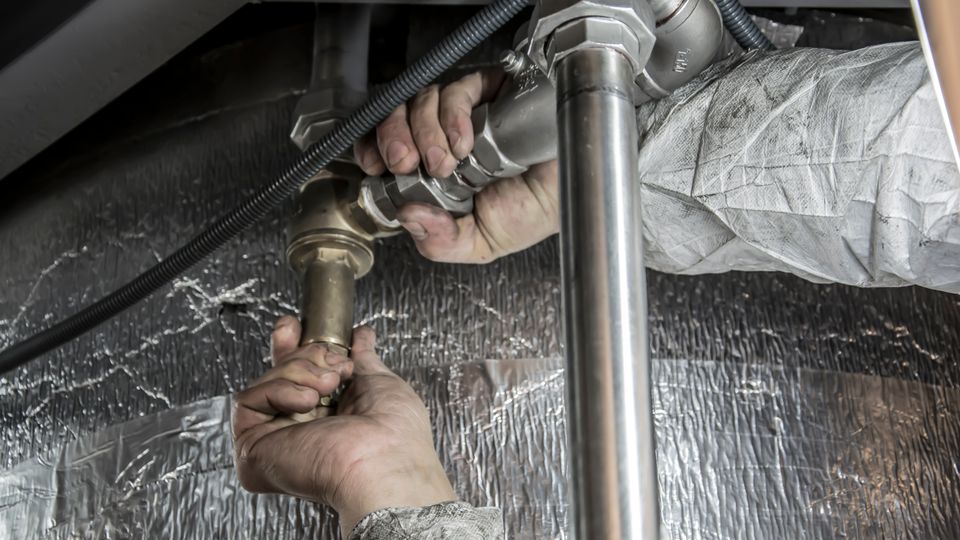 Close-up of a plumber installing steel pipe fittings
