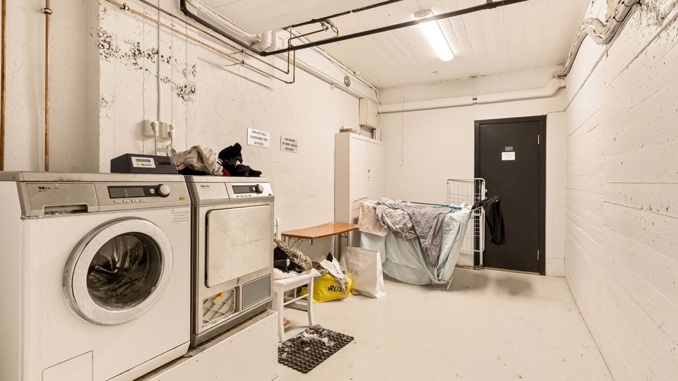 Laundry room with washing machine and exposed utility piping